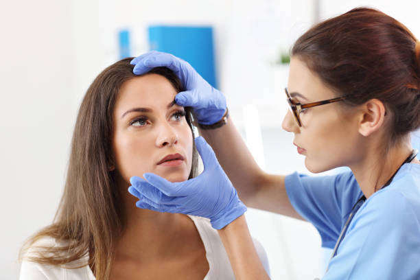 Dermatologist examining female patient's skin in clinic